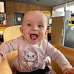 Joue, Sourire, Bras, Sleeve, Baby & Toddler Clothing, Yellow, Table, Baby, T-shirt, Chair, Happy, Bambin, Fun, Enfant, Assis, Comfort, Room, Baby Laughing, Personne