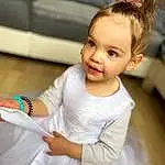 Hair, Peau, Shoulder, Facial Expression, Dress, Neck, Sleeve, Happy, Gesture, Baby & Toddler Clothing, Finger, Bun, Bambin, Jewellery, Enfant, Event, Fashion Design, Bridal Clothing, Fun, Wedding Ceremony Supply, Personne
