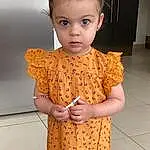 Peau, Facial Expression, Eyelash, Neck, Sleeve, One-piece Garment, Dress, Yellow, Day Dress, Waist, Baby & Toddler Clothing, Fashion Design, Trunk, Jewellery, Bambin, Formal Wear, Necklace, Pattern, Enfant, Embellishment, Personne