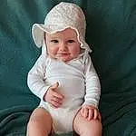 Visage, Joue, Head, Lip, Yeux, Baby & Toddler Clothing, Human Body, Baby, Neck, Sleeve, Iris, Flash Photography, Headgear, Comfort, Happy, Sourire, Bambin, Knee, Thumb, Nail, Personne, Headwear