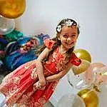 Sourire, Facial Expression, Happy, Yellow, Dress, Balloon, Fun, Fashion Design, Event, Jewellery, Formal Wear, Headpiece, Gown, Party Supply, Enfant, Performing Arts, Jouets, Party, Tradition, Fashion Accessory, Personne, Joy, Headwear