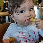 Nez, Joue, Peau, Nourriture, Baby Playing With Food, Facial Expression, Tableware, Mouth, Food Craving, Yellow, Baby, Bambin, Chair, Cuisine, Biting, Drinkware, Sweetness, Enfant, Comfort Food, Junk Food, Personne