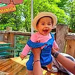 Clothing, Sourire, Arbre, Happy, Yellow, Rose, Leisure, Thigh, Public Space, Baby & Toddler Clothing, Herbe, Bambin, Recreation, People In Nature, Chapi Chapo, Electric Blue, Sun Hat, Fun, Human Leg, Lap, Personne, Headwear