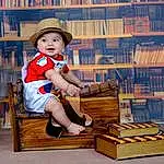 Chapi Chapo, Sun Hat, Bois, Bookcase, Idiophone, Happy, Musical Instrument, Baby & Toddler Clothing, Bambin, Publication, Book, Shelf, Assis, Recreation, Baby, Cowboy Hat, Fashion Accessory, Shelving, Leisure, Enfant, Personne, Headwear