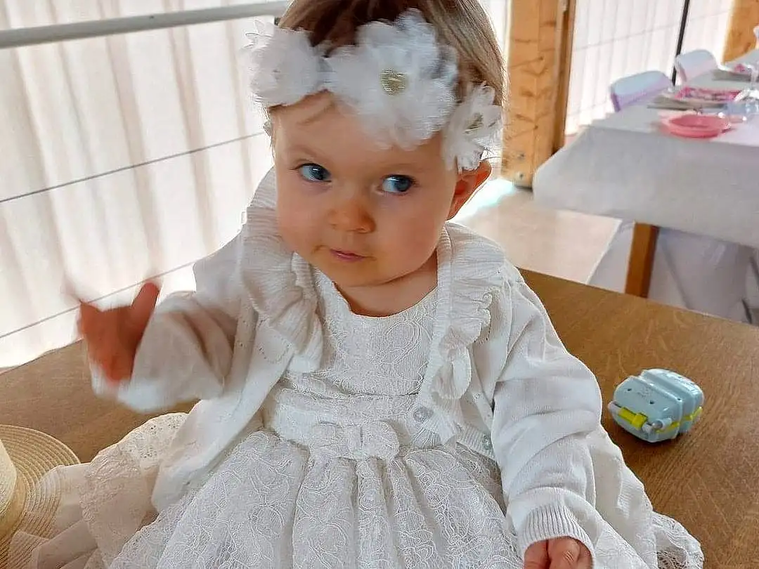 Visage, Yeux, Blanc, Dress, Baby & Toddler Clothing, Textile, Sleeve, Embellishment, Iris, One-piece Garment, Rose, Day Dress, Headpiece, Bambin, Gown, Bridal Accessory, Ruffle, Fashion Design, Happy, Personne, Headwear