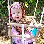 Plante, Jouets, Botany, Textile, Purple, Doll, Rose, Herbe, People In Nature, Faon, Summer, Leisure, Magenta, Enfant, Outdoor Furniture, Thigh, Sourire, Pattern, Happy, Baby & Toddler Clothing, Personne, Headwear