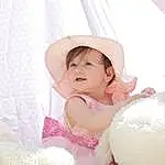 Textile, Happy, Rose, Baby & Toddler Clothing, Headgear, Baby, Flash Photography, Bambin, Comfort, Sourire, Event, Fashion Accessory, Sweetness, Sun Hat, Pattern, Enfant, Hair Accessory, Peach, Embellishment, Portrait Photography, Personne