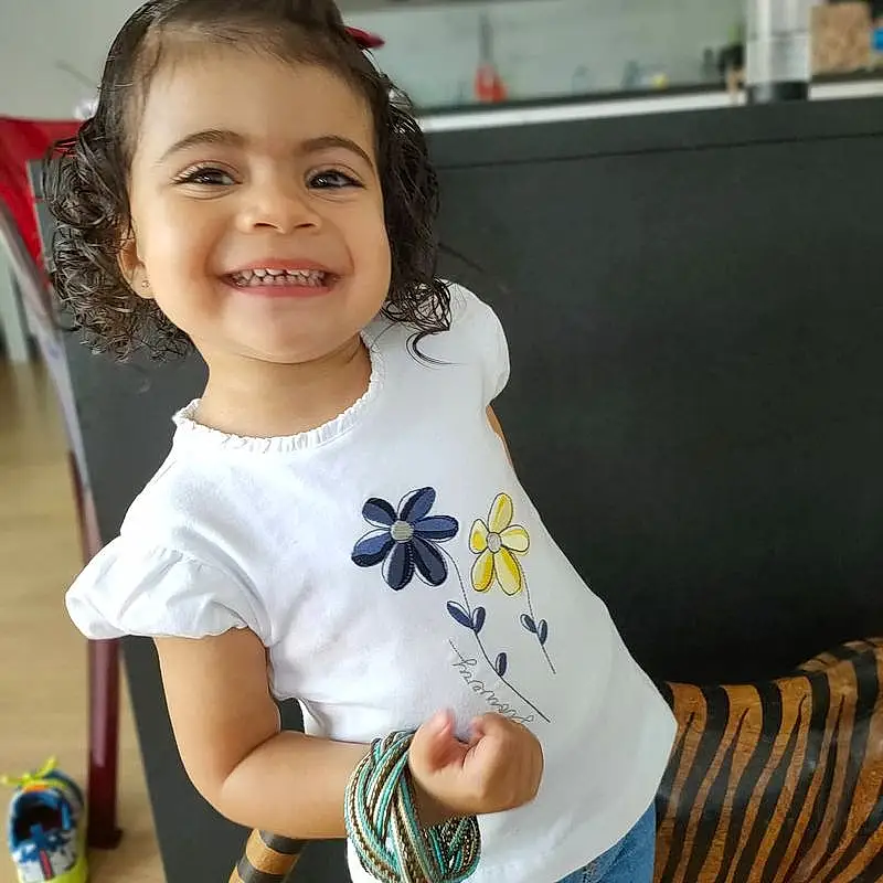 Peau, Sourire, Neck, Sleeve, Happy, Baby & Toddler Clothing, Gesture, Bambin, T-shirt, Thumb, Enfant, Fun, Jouets, Elbow, Baby Playing With Toys, Pattern, Nail, Room, Play, Necklace, Personne, Joy