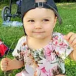 Peau, Hand, Plante, Facial Expression, Baby & Toddler Clothing, Happy, Cap, Rose, Finger, People In Nature, Herbe, Headgear, Leisure, Bambin, Recreation, Baby, Enfant, Fun, Assis, Sun Hat, Personne, Joy, Headwear