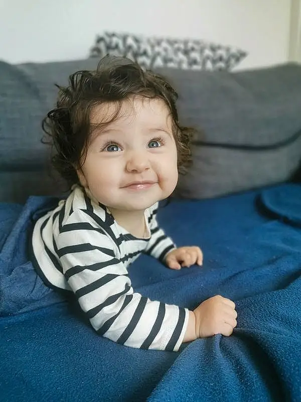 Visage, Hair, Joue, Head, Sourire, Yeux, Comfort, Sleeve, Flash Photography, Iris, Gesture, Grey, Baby & Toddler Clothing, Bambin, Happy, Couch, Electric Blue, Baby, Enfant, Fun, Personne, Joy