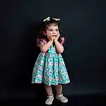 One-piece Garment, Flash Photography, Dress, Baby & Toddler Clothing, Sleeve, Happy, Gesture, Sourire, Day Dress, Bambin, Fashion Design, Electric Blue, Magenta, Human Leg, Pattern, Fun, Fashion Accessory, Embellishment, Enfant, Portrait Photography, Personne