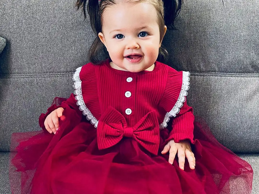 Clothing, Visage, Sourire, Head, VÃªtements dâ€™extÃ©rieur, Coiffure, Dress, Purple, Baby & Toddler Clothing, Neck, Sleeve, Happy, Iris, Rose, Violet, Bambin, Red, Magenta, Baby, Couch, Personne