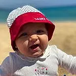 Clothing, Joue, Peau, Lip, Photograph, Cap, Ciel, Sleeve, Happy, Baby & Toddler Clothing, Bambin, Headgear, Sourire, Enfant, Voyages, Baby, Chapi Chapo, Plage, Personal Protective Equipment, Fashion Accessory, Personne, Headwear