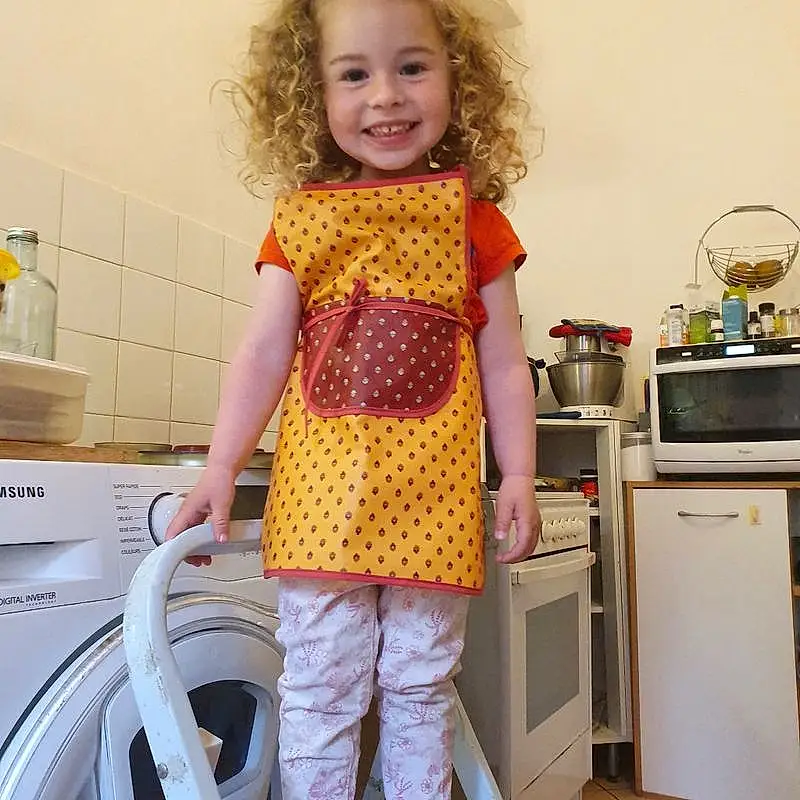 Clothing, Sourire, Laundry Room, Cabinetry, Kitchen Appliance, Kitchen, Sleeve, Home Appliance, Purple, Debout, Yellow, Rose, Major Appliance, Baby & Toddler Clothing, Homemaker, Enfant, Bambin, T-shirt, Room, Countertop, Personne, Joy