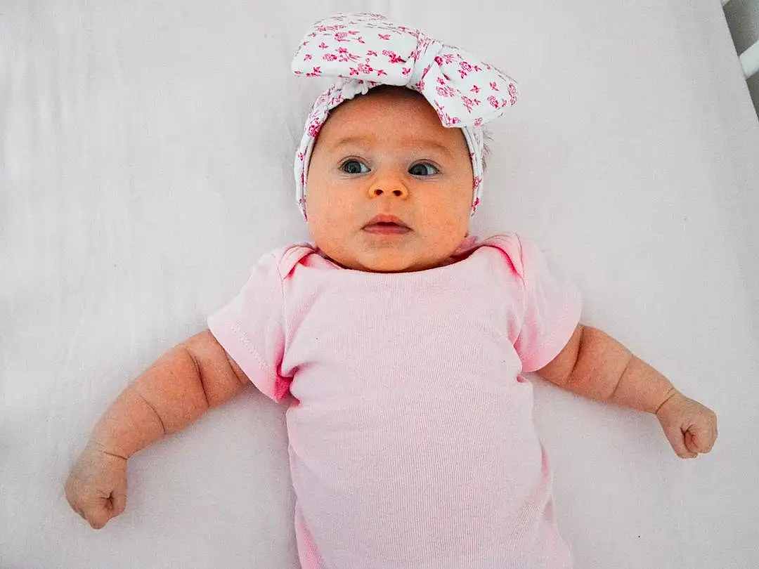 Joue, Lip, Baby & Toddler Clothing, Sleeve, Baby, Gesture, Rose, Happy, Collar, Bambin, Magenta, Eyelash, Linens, Enfant, T-shirt, Peach, Fashion Accessory, Pattern, Costume Hat, Portrait Photography, Personne, Headwear