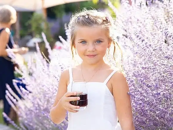 Sourire, Coiffure, Plante, Facial Expression, Purple, Fashion, Happy, Dress, Bridal Clothing, Summer, Formal Wear, Gown, Fun, Wine Glass, Wedding Dress, Herbe, Event, Jewellery, Petal, Leisure, Personne, Joy