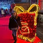 Sourire, Decoration, Entertainment, Happy, Leisure, Event, Fun, Holiday, Christmas Decoration, Electric Blue, Neon, Pedestrian, Luggage And Bags, Tradition, Noël, Street, Night, Bag, Christmas Lights, Personne, Joy, Headwear