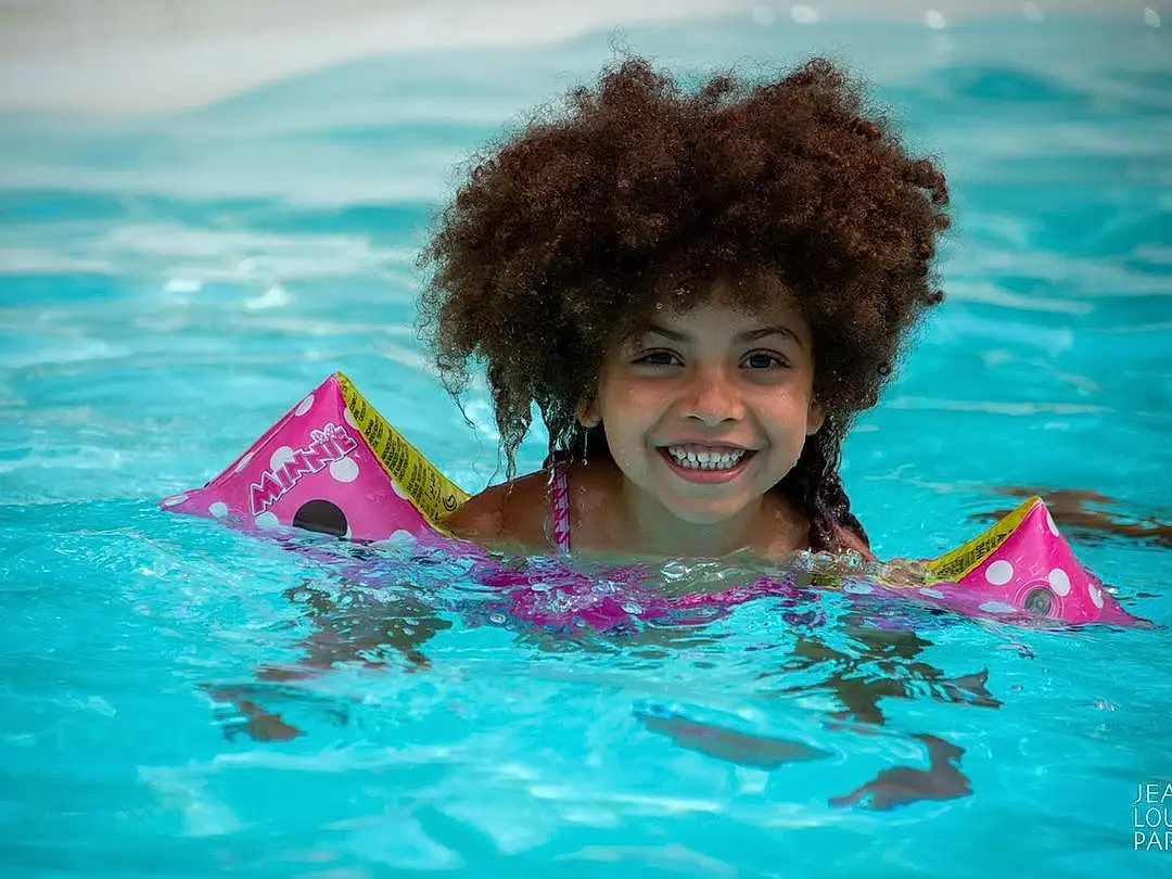 Hair, Sourire, Eau, Head, Coiffure, Azure, Happy, Leisure, People In Nature, Fun, Aqua, Swimwear, Summer, Swimming Pool, Recreation, Magenta, Personal Protective Equipment, Bambin, Voyages, Bathing, Personne, Joy